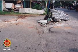 Papan bertuliskan “Posko Peduli Sangkal Menerima Bantuan” yang dipasang di pertigaan menuju Dusun...