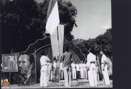 Petugas pengibar bendera sedang menaikkan bendera. Diikuti para peserta menyanyikan lagu Indonesi...