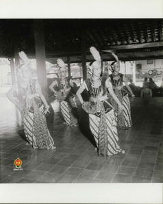 Para penabuh gamelan sedang mengiringi tarian para penari serimpi di sebuah pendapa.