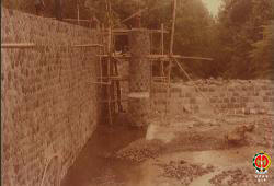 Bangunan bendung irigasi yang hampir selesai dikerjakan 85% tampak dari samping.