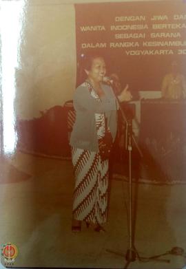 Ibu Sumidjan sedang menyanyi diiringi musik kulintang oleh ibu-ibu